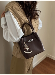 Detailed close-up of dark brown lychee leather bucket bag with silver metal swivel lock