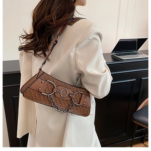 Close-up of vintage brown woven bag featuring metal rings and chain details on a strap