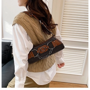 Detail of vintage patchwork crossbody bag with silver rings and chain on model
