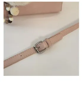 Détail de la bandoulière réglable du sac seau rose avec boucle en métal argenté élégante