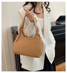 Detail of woven khaki bucket bag showing intricate texture and adjustable metal buckle