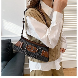Detail of woven texture shoulder bag with silver rings and adjustable strap on model