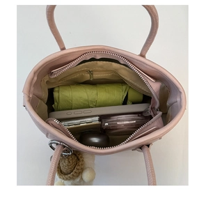 Vue intérieure du sac seau rose montrant sa grande capacité avec parapluie et mobile