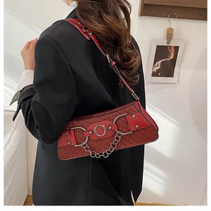 Detail of red woven motorcycle bag with silver metal ring and chain on a model