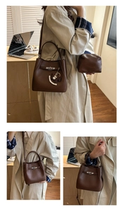 Detail of dark brown pebble leather bucket bag with silver turn-lock and horse charm