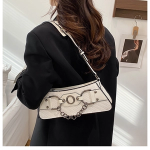 Chic cream woven leather shoulder bag styled on model featuring metal ring and rivet details