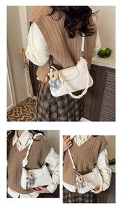 Detailed view of white leather square bag with woven strap and cute teddy bear charm