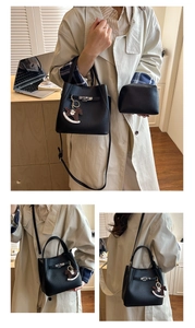 Detail of black lychee grain bucket bag with silver twist lock and horse charm