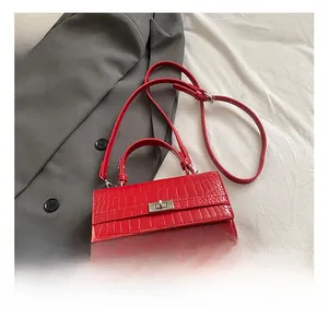 Detail of red crocodile texture handbag with silver twist lock on white background