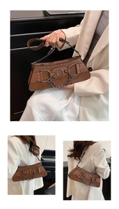 Detail of vintage brown woven leather bag with metallic horsebit buckle and chain strap