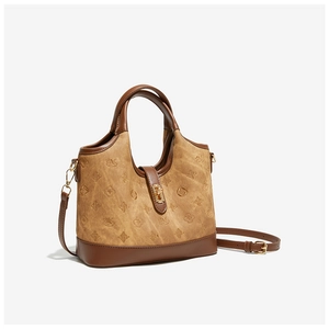 Detail of caramel bucket bag with vintage monogram patterns and golden metal lock