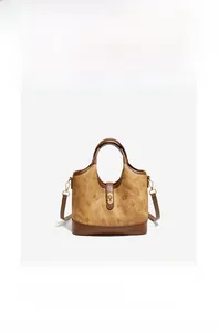 Detail of vintage brown bucket bag with embossed floral patterns and leather trim