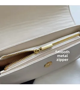Close-up of white leather baguette bag with premium gold zipper and magnetic closure