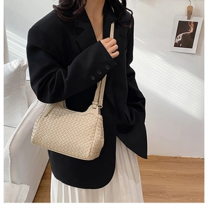 Detail shot of beige woven leather texture on a stylish hobo shoulder bag for women