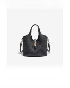 Detail view of black vintage bucket bag with embossed patterns and gold hardware