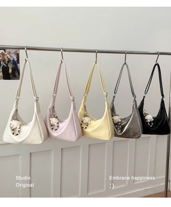 Detailed display of crescent tote bags in five colors with pleated leather and charms