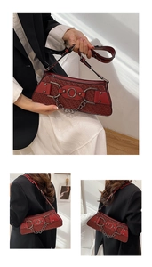 Detail of red woven texture baguette bag with vintage metal ring and thick chain