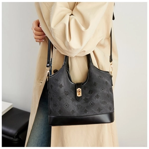 Close-up of vintage bucket bag featuring embossed swan motifs and golden metal twist lock
