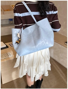 Détail du grand sac cabas bleu clair avec pompon en perles de bois et couture verticale