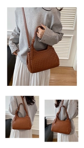 Detail of brown woven leather handbag showing intricate texture and golden metal buckles
