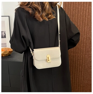 Vista posteriore di una borsa a tracolla crema chic indossata per uno stile casual