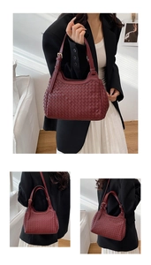 Detail of dark red woven leather texture and golden metal buckle on a shoulder bag