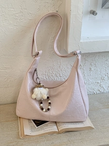 Pink crescent hobo bag with wrinkled texture, plush charm and beaded tassels