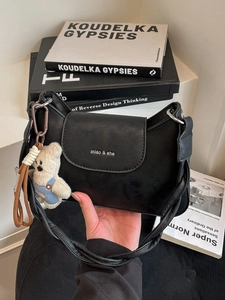 Minimalist black square shoulder bag with woven strap and cute bear plush charm