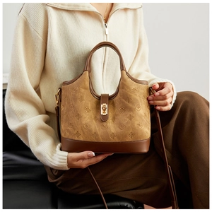 Detail of camel bucket bag with embossed monogram and golden twist lock closure