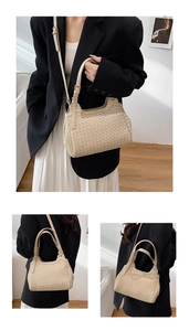 Detail view of woven cream bucket bag with adjustable strap and metallic hardware