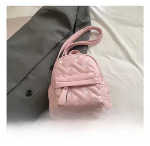 Detail of pink quilted backpack with white heart embroidery and zipper pocket
