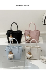 Détail de quatre sacs fourre-tout de couleurs assorties avec des breloques de gnomes