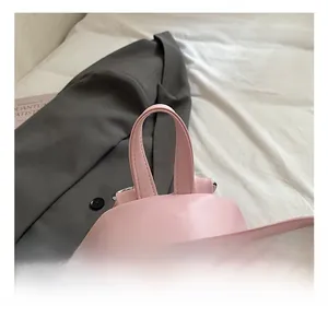 Detailed view of pink PU backpack with silver double zippers and comfortable top handle