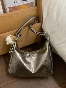 Metallic bronze wrinkled leather tote bag with a plush charm accessory