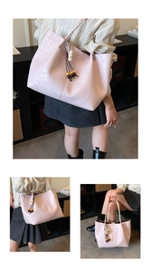 Détail d'un sac cabas en similicuir rose clair avec pendentif perles et fleurs en bois