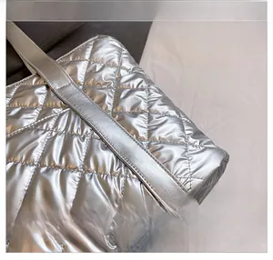 Dettaglio della borsa tote argento trapuntata con texture metallica e motivo a rombi