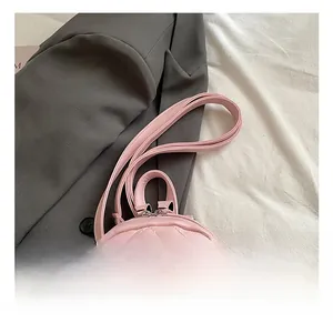 Detailed view of pink mini backpack featuring heart-shaped quilting and silver zippers