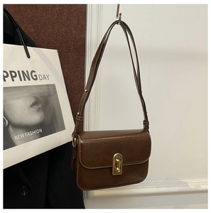 Dettaglio della borsa vintage marrone scuro in ecopelle con elegante chiusura dorata