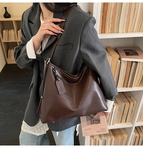 Detail of deep brown leather tote bag showing smooth texture and vintage shoulder strap
