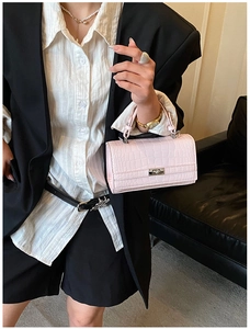 Close-up of pink crocodile texture leather handbag with silver metallic twist lock closure