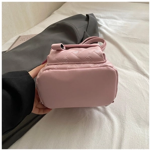 Close-up of pink quilted mini backpack featuring heart-shaped stitching and smooth base