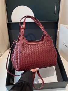 Burgundy woven leather bucket bag with top handles and adjustable strap in a gift box