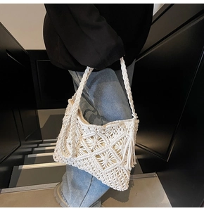 Détail d'un sac en corde de coton blanc avec pompon fait main et motif losange évidé
