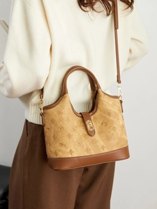 Vintage brown crossbody bucket bag with monogram pattern and gold lock buckle detail
