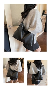 Detailed view of a large black faux leather tote bag with decorative side tag for work