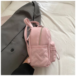 Detail of pink mini backpack featuring heart quilted pattern and silver metal zippers
