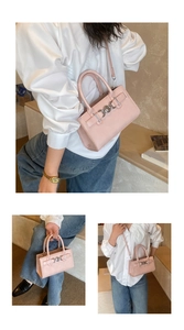 Detail view of pink square handbag showing top handles and silver metal clasp