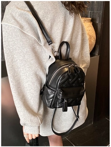 Close-up of heart quilted mini backpack in black PU leather with silver hardware