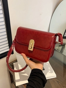 Borsa a spalla rossa lucida con chiusura a rotazione dorata e design rettangolare vintage
