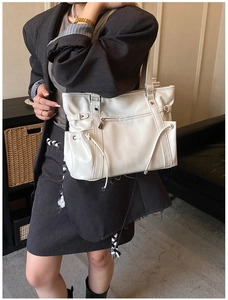 Modern white large tote bag shown as a shoulder bag on a model in a gray suit